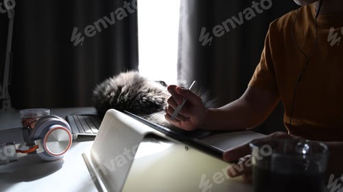 Preview: Cropped shot of man working with digital tablet while sitting with his cat in living room.