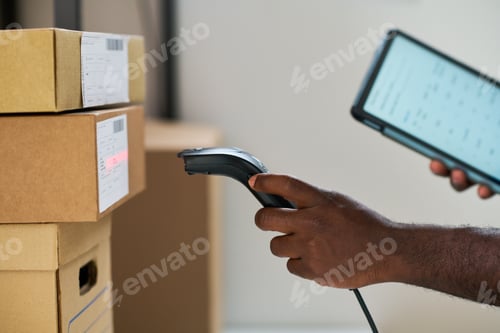 Preview: Young Adult Black Man Verifying Parcel Information Using Barcode Scanner and Tablet