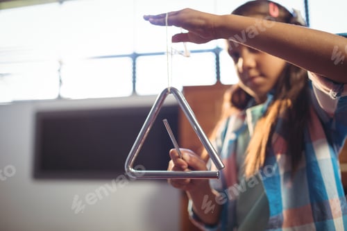 Preview: Girl playing triangle in classroom
