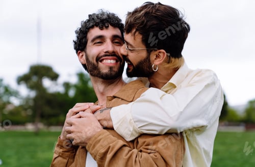 Preview: Happy gay couple embracing in back hug while in park