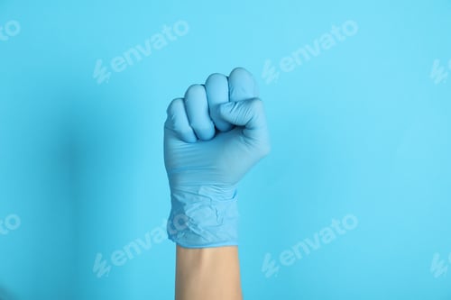 Preview: Gloved Hand Raised on a Blue Background