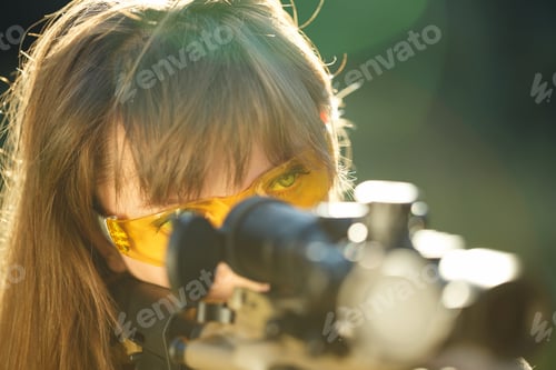 Preview: Girl with a gun for trap shooting and shooting glasses aiming at