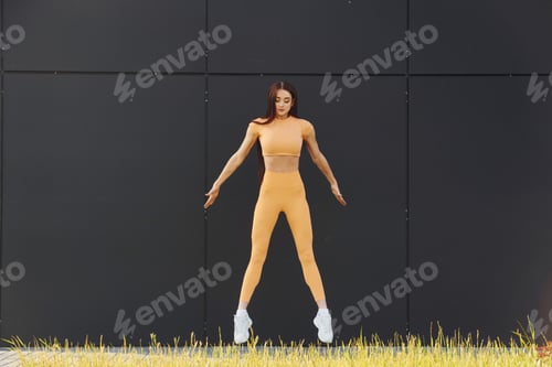 Preview: Stretching exercises. Young woman in sportswear have fitness session outdoors