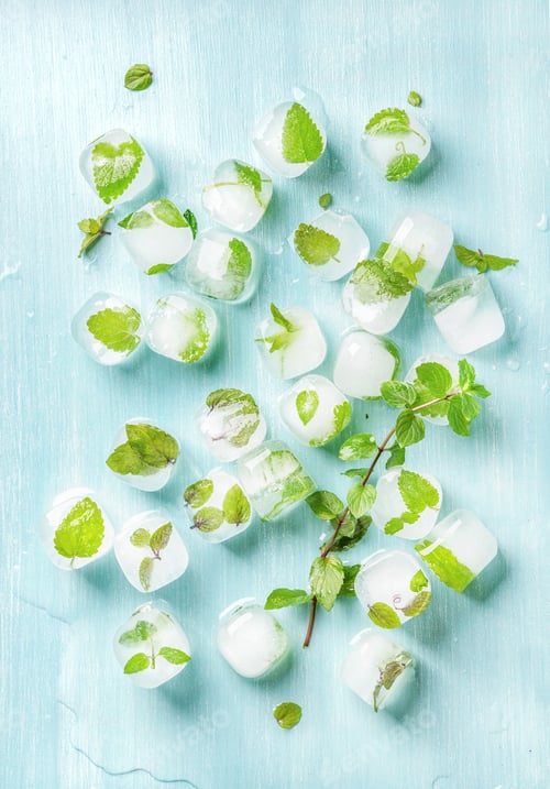 Preview: Ice cubes with frozen mint leaves inside on blue Turquoise background, top view