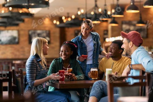 Preview: Young happy people communicating while enjoying in a bar.