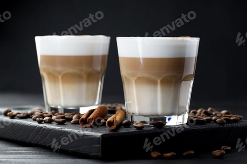 Preview: Tasty latte macchiato in glasses, coffee beans and cinnamon on black wooden table, closeup