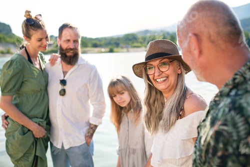 Preview: Happy multigeneration family on summer holiday, walking by lake