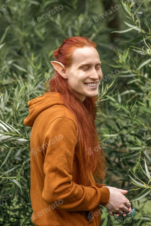 Preview: Artistic elf man with red hair and green eyes in the forest