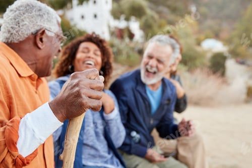 Preview: Group Of Senior Friends On Hike In Countryside Looking At Mobiles Phones Together