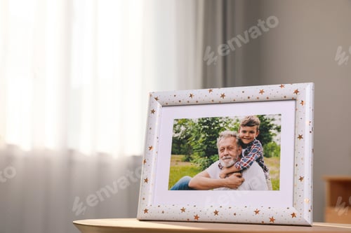 Preview: Framed family photo on wooden table in room. Space for text