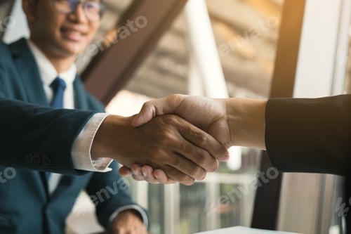 Preview: Entrepreneurs collaboration deal shaking hands in a modern office and financial paper graph on desk.