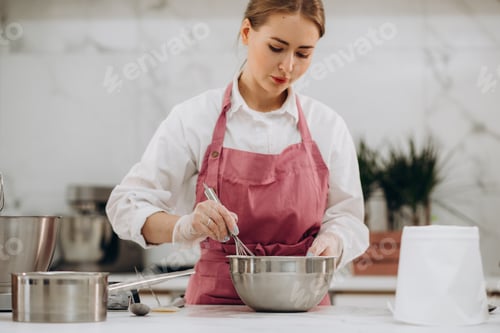 Preview: A woman confectioner prepares delicious desserts in a bright kitchen. Meringue desserts. High qualit