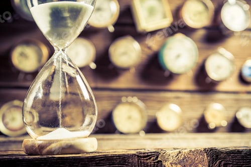 Preview: Closeup of old hourglass on clocks background