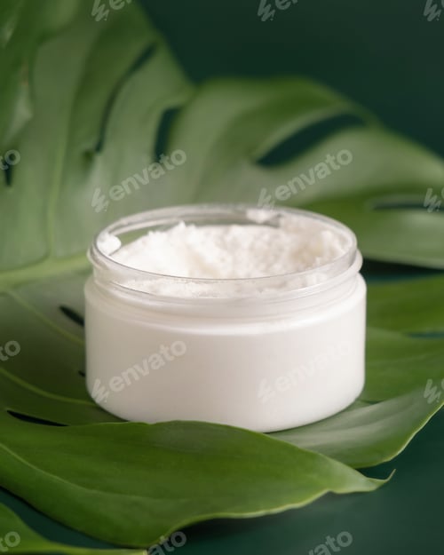 Preview: White jar on monstera leaf on green table close up. Brand packaging mockup