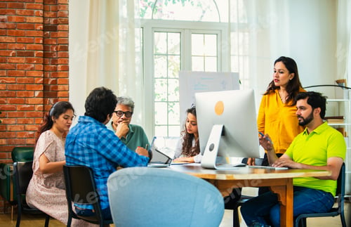 Preview: Young Indian entrepreneurs brainstorming project ideas with a laptop and paperwork in office