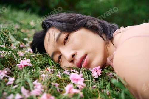 Preview: Young man in stylish grey attire embraces nature in a serene park setting