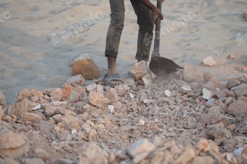 Preview: Construction worker shoveling rubble on a work site