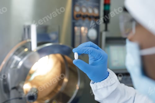 Preview: Pharmaceutical Worker Inspects Pill for Quality Control in Modern Medicine Manufacturing Facility