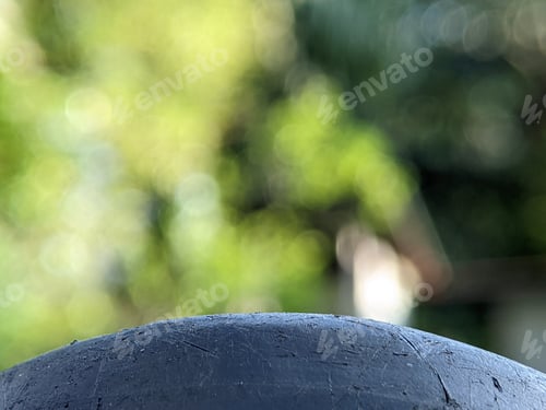 Preview: Closeup black surface with blurry nature background