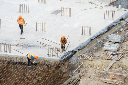 Preview: concreting work: construction site worker during concrete pouring into formwork at building area