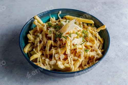 Preview: Bowl of french fries topped with sauce