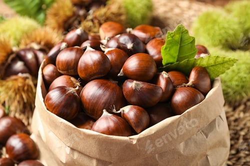 Preview: Fresh sweet edible chestnuts in paper bag, closeup