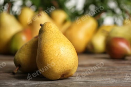 Preview: Fresh ripe pears on wooden table against blurred background