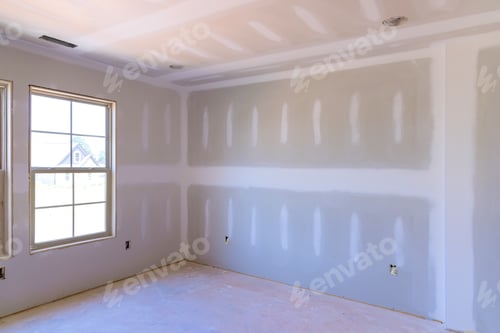 Preview: New drywall installed in empty room awaiting finishing touches