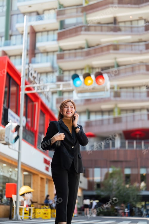Preview: Asian professional businesswoman holding cellphone using smartphone standing or walking on big city