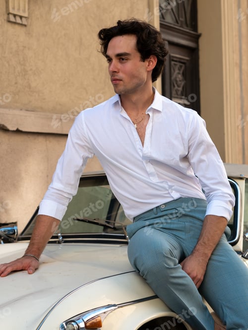 Preview: Attractive, Handsome Man Leaning On A Retro Car In A White Shirt. Mediterranean Vibe