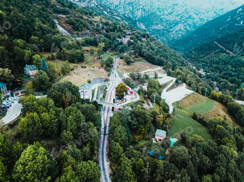 Preview: Aragon, Spain - August 2, 2019: A train station between the mountains, seen from above aerial.