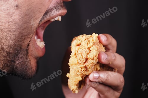 Preview: Enjoying a crispy fried chicken piece in a casual setting