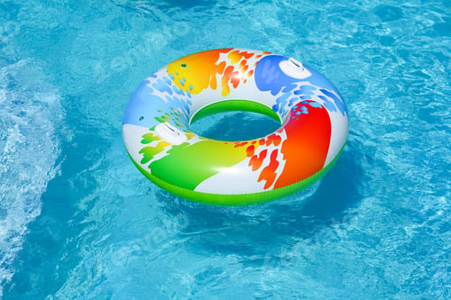 Preview: Colorful inflatable ring floating in swimming pool on sunny day