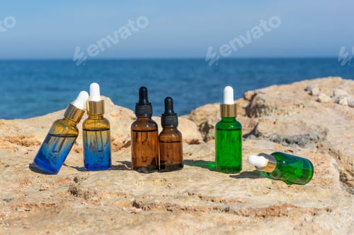 Preview: Natural essential oils or serum in dropper bottles standing on the stones at the seaside