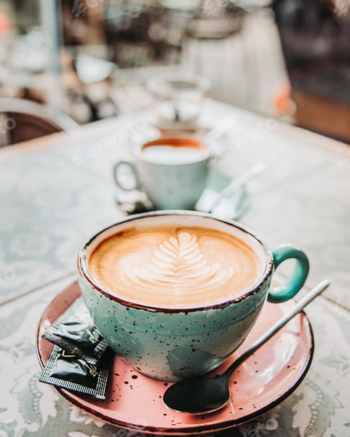 Preview: Cup of cappuccino with latte art served at the cafe