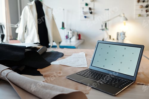 Preview: Focus on laptop standing on workplace of leatherworker or tanner