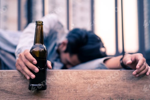 Preview: Asian drunk man feeling stress from life problem, holding beer bottle and lying on floor.