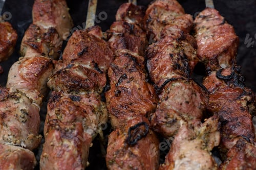 Preview: Grilled skewers of meat on the coals, with smoke. street food.