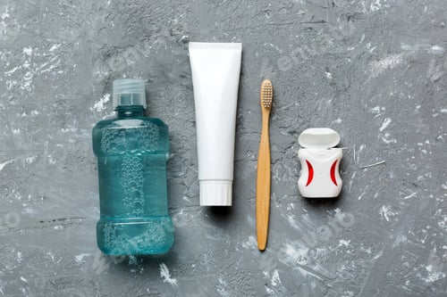 Preview: Mouthwash and other oral hygiene products on colored table top view with copy space