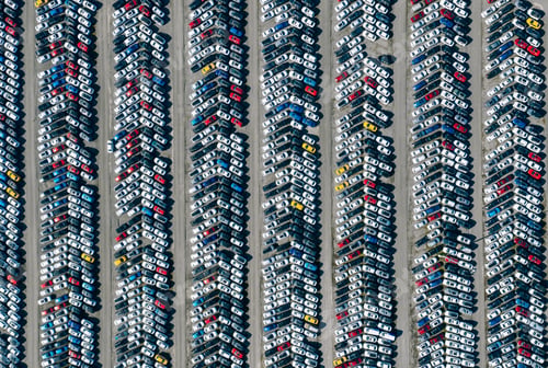 Preview: Aerial drone view of Parking lot. New cars storage area. Many cars parked in a rows