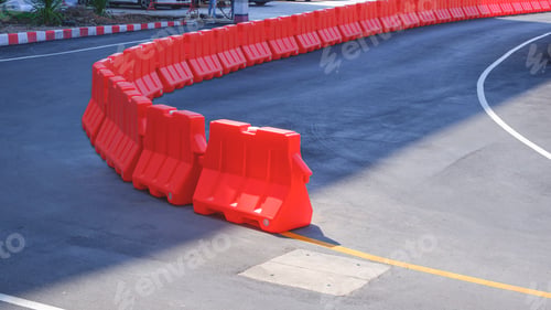 Preview: Row of orange plastic barriers on curve asphalt road in outdoor car park area