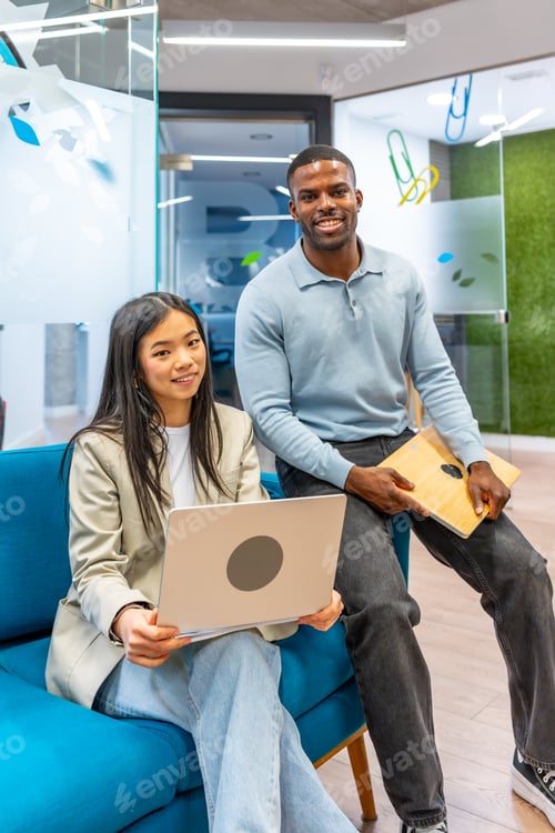 Preview: Smiling business people holding laptop and tablet in coworking office