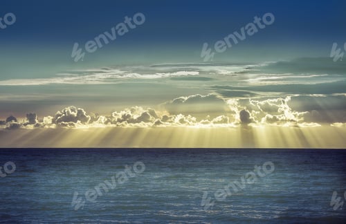 Preview: Rays of Sunlight Shining Through Clouds Over Ocean
