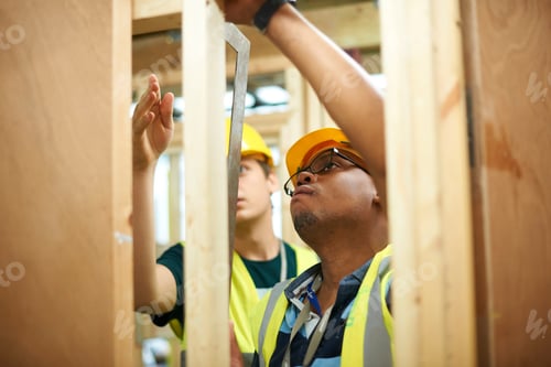Preview: Male higher education students building wooden framework in college workshop
