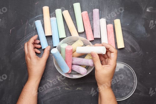 Preview: Multicolored chalk in a plastic bucket on a black background