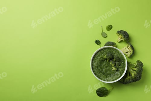 Preview: Broccoli cream soup on green background, top view