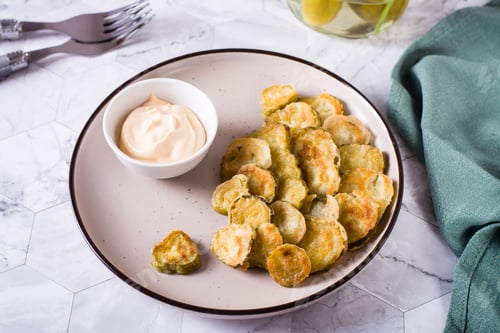 Preview: Fried pickles appetizer and sauce in a bowl on a plate. Homemade snack.