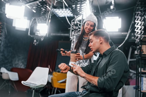Preview: Young man is preparing for TV online broadcast. Woman helps with make up