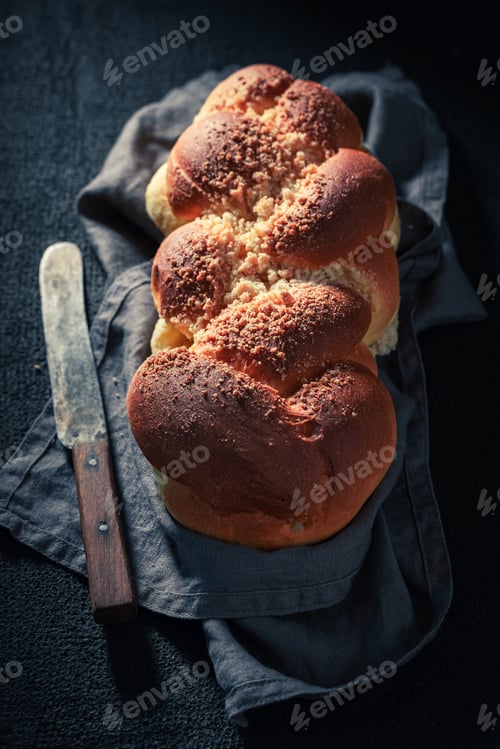 Preview: Golden challah on dark table for breakfast
