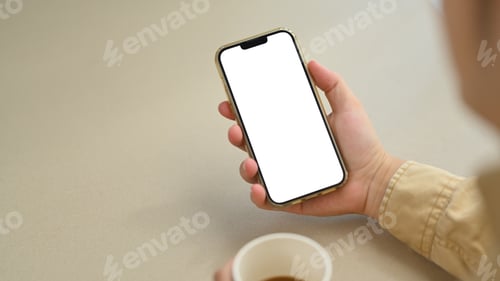 Preview: Young man using smartphone during coffee break at his workplace